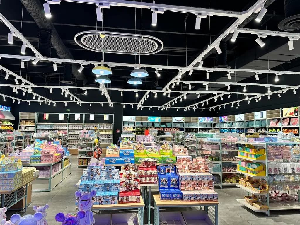 Interior de tienda de juguetes y coleccionables con iluminación de rieles y estantería de figuras